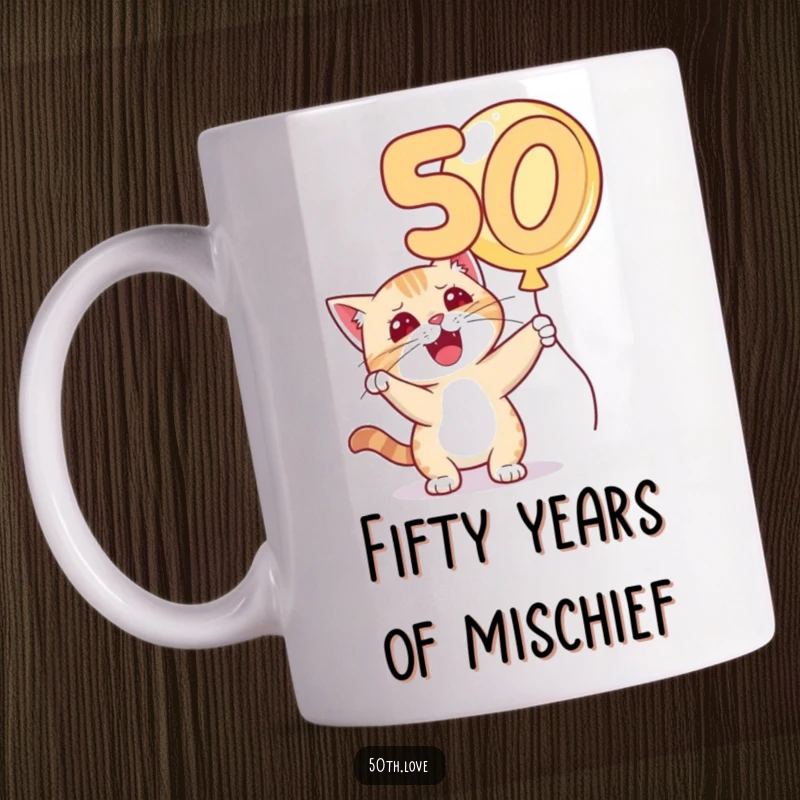 Funny 'Cat 50th Birthday' Mug: A playful cat with a mischievous grin bats at a floating golden number 50 balloon.