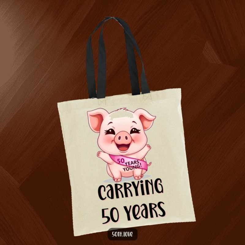 Funny 50th birthday tote bag with a giggling piglet sporting a '50 Years Young' sash, ideal for stylish and humorous errands.