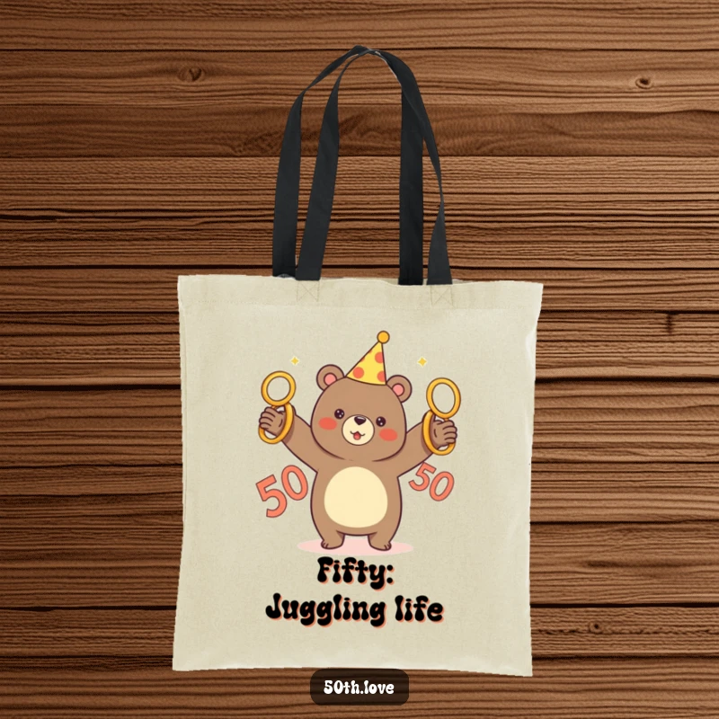 Funny tote bag featuring a bear in a party hat triumphantly juggling five golden rings, a 50 symbol present.